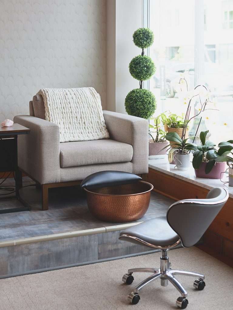 Aurora Spa 12 Cozy chair in the window of Aurora Spa in Minneapolis with a copper foot washing bowl.