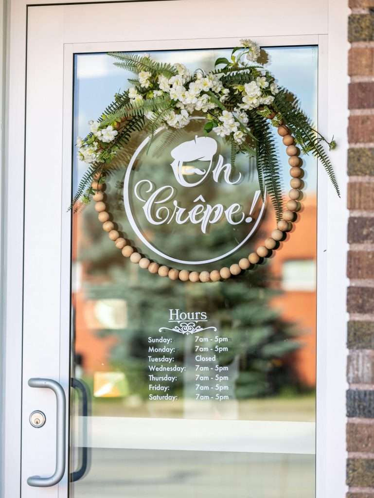 Oh Crêpe! Creperie & Café 4 Front door of Oh Crepe Cafe in Edina with store hours shown.