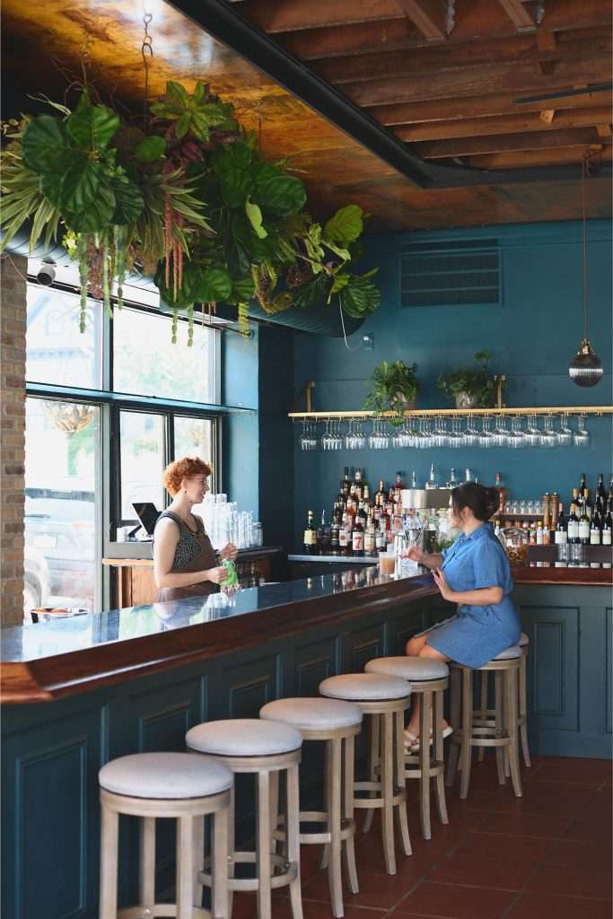 Minneapolis Restaurant Design 15 Modern bar with plants and patrons