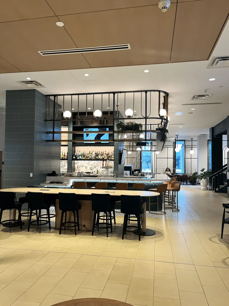 Esther's Table: Bringing a Legendary Minneapolis Hostess Back to the Table 19 Esther's Table bar before the Tiffany Hanken Design refresh, with empty brass shelving and no greenery or collected objects