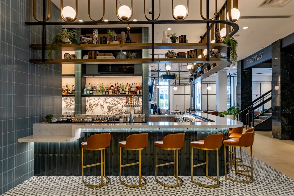 Esther's Table: Restaurant Interior Design, Minneapolis 21 Esther's Table cocktail bar in Minneapolis with a brass globe-light canopy, sage tile, marble back bar and cognac leather stools