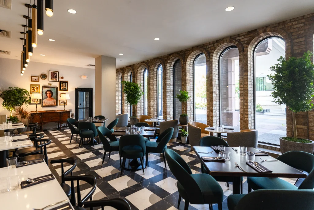 Esther's Table: Restaurant Interior Design, Minneapolis 16 Esther's Table dining room with teal chairs, checkerboard marble floor, arched brick windows and a portrait of Esther Capp