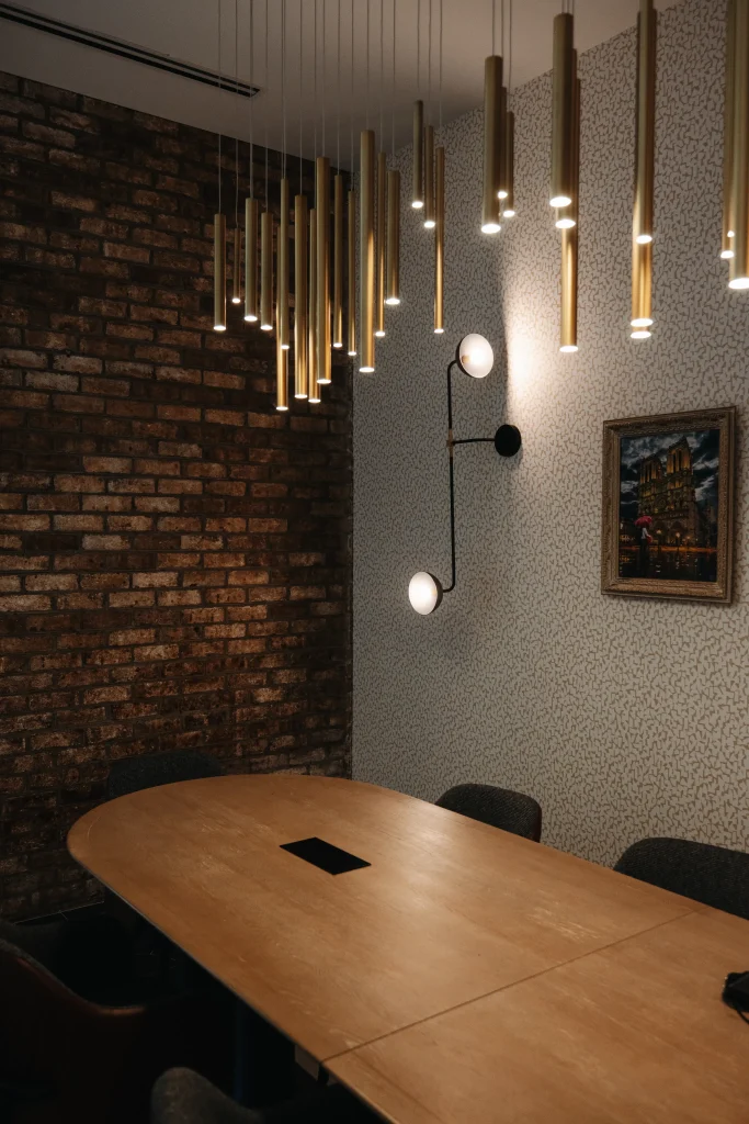 Esther's Table: Restaurant Interior Design, Minneapolis 7 Private dining room at Esther's Table with an oak table, exposed brick wall, cascading brass pendant lighting and framed Paris artwork