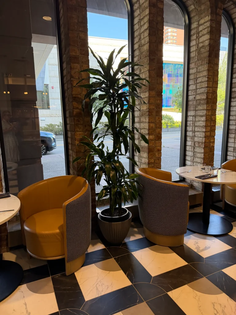 Esther's Table: Restaurant Interior Design, Minneapolis 26 Mustard barrel chairs and round tables beside tall arched brick windows