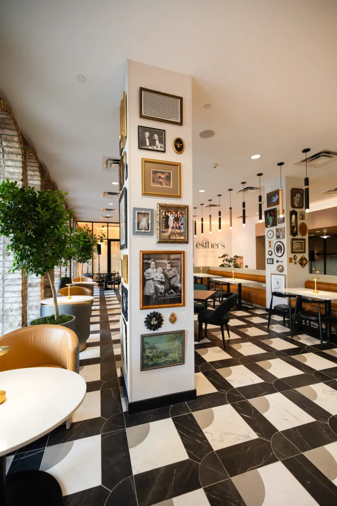 Esther's Table: Restaurant Interior Design, Minneapolis 4 Column wrapped in vintage-framed Capp family photographs, a bee medallion and antique art beside brick arches and topiaries