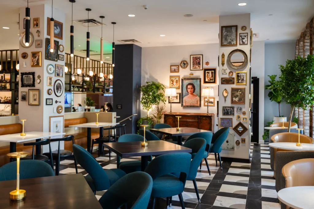 Esther's Table: Restaurant Interior Design, Minneapolis 5 Dining room columns wrapped in eclectic framed art and mirrors, flanking a portrait of Esther Capp above an antique sideboard
