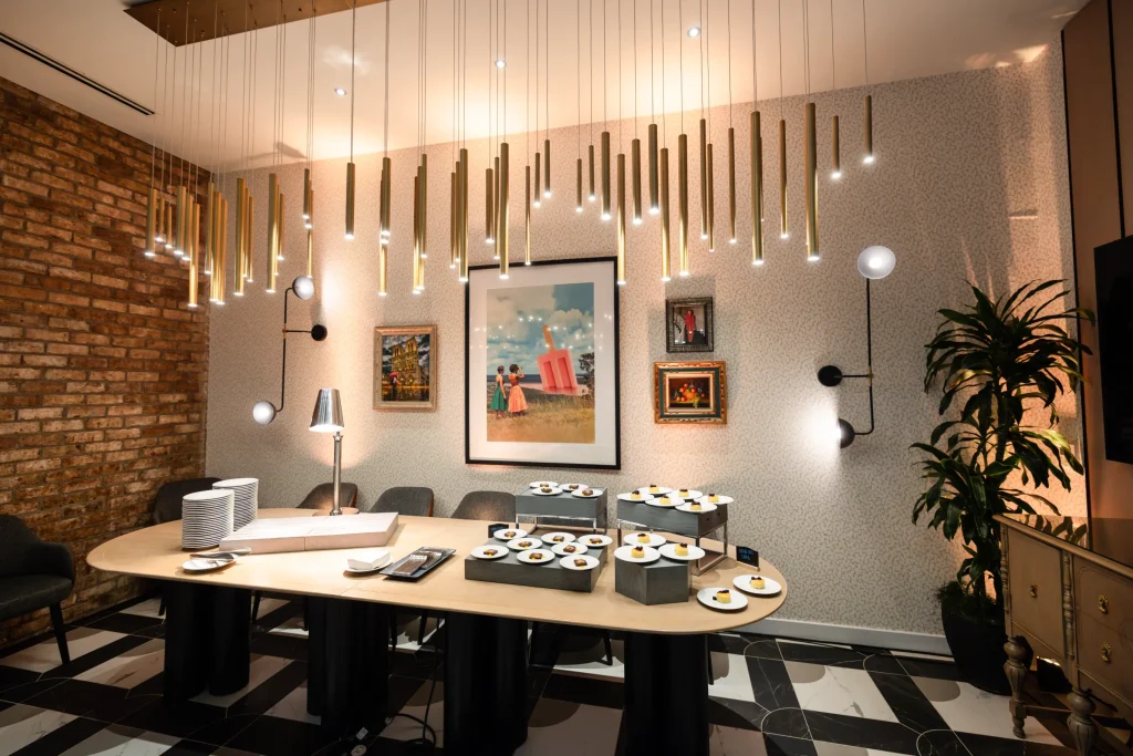 Esther's Table: Restaurant Interior Design, Minneapolis 2 Private dining room with a collage of vintage and contemporary artwork, cascading brass pendant lights and a dessert service on the oak table